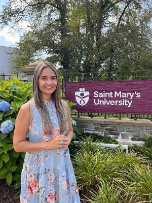 A student posing in front of the SMU sign