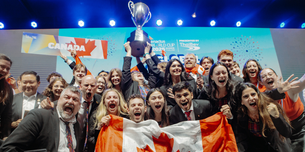 Enactus team holds a trophy and Canadian flag