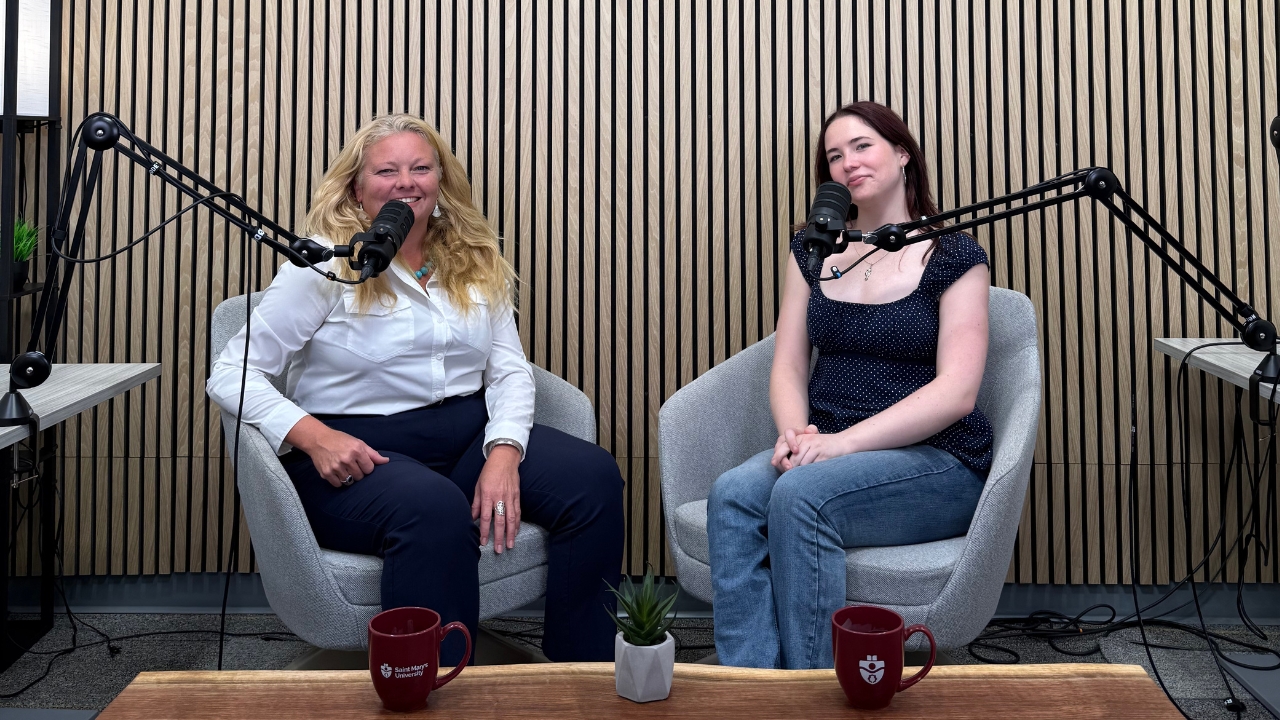 A professor and student sit together in the podcast studio
