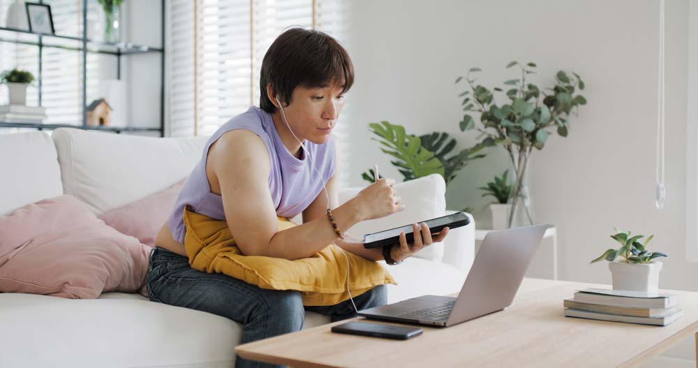Woman siting on a couch looking at laptop screen