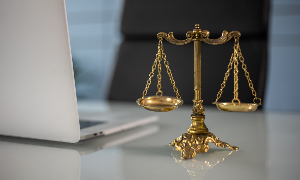 A miniature scales of justice sits on a desk